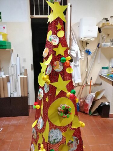 A estrutura da árvore de Natal foi recuperada pois já não estava funcional e foi enfeitada com bolas e estrelas concebidas com as embalagens Tetra Pak, pintadas com spray de cor amarela.