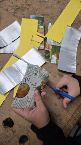 Recorte das tiras para o revestimento<br/>Recorte das embalagens Tetra Pak e restos de cartolina amarela em tiras, realizando pequenos cortes imitando as "agulhas" dos pinheiros.