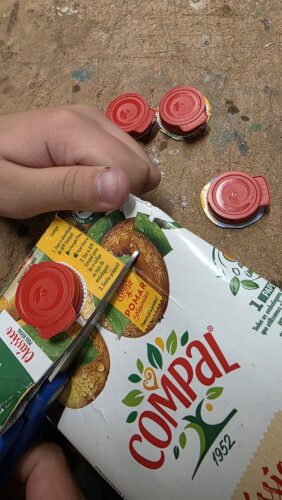 Elementos decorativos<br/>Recorte e colagem das tampas das embalagens Tetra Pak para decorar a árvore.