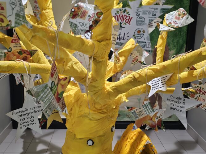 Árvore amarela com os símbolos da marca Compal e Tetra Pak.