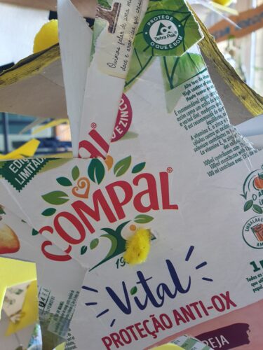 Estrela recortada de embalagens, onde são visíveis os símbolos da Compal e da Tetra Pak.