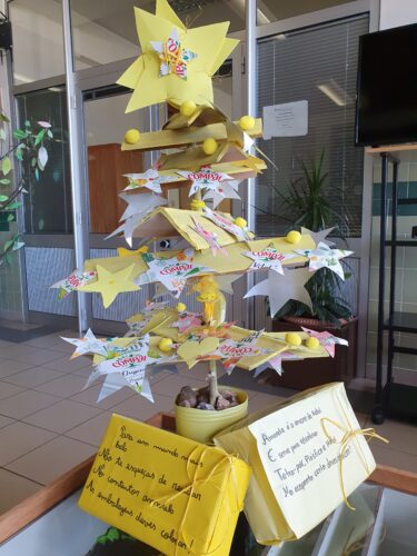 Árvore de Natal Amarela com mensagens de incentivo à reciclagem de embalagens.