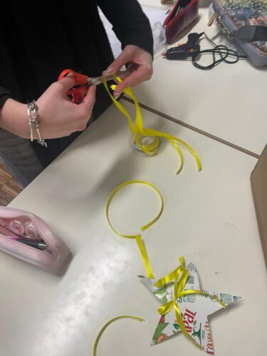 Com a colaboração dos alunos, foram preparados os laços amarelos para aplicar nas embalagens, previamente cortadas em forma de estrela.