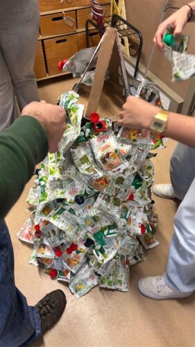Processo de construção da Árvore de Natal Amarela<br/>Fase de colagem das embalagens Tetra Pak da marca Compal à estrutura em cartão reutilizado, dando forma e volume aos ramos da Árvore de Natal Amarela através da reutilização criativa de materiais.