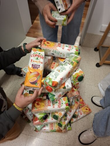 Os alunos fazem experiências com as embalagens para decidir como será a construção da árvore.