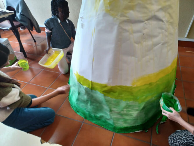 O cone de papelão foi revestido com restos de papel cenário e pintado em degradê (amarelo e verde).