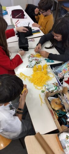 Equipa de alunos a preparar enfeites com lã reutilizada, cartão reaproveitado e embalagens Compal, promovendo criatividade, reutilização e trabalho cooperativo.