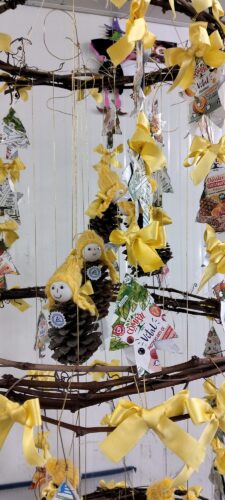 Destaque para as estrelas e figuras recortadas diretamente de embalagens Compal e Tetra Pak, evidenciando claramente logotipos, símbolos ambientais e a reutilização criativa dos materiais.