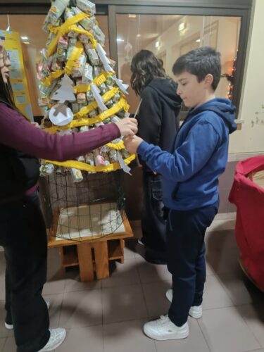 Embelezamento da árvore com a colocação das ultimas embalagens Tetra Pak e de elementos decorativos.